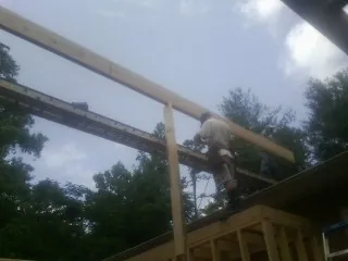 Carpenter setting a ridge beam over a new addition frame in Ridgefield
